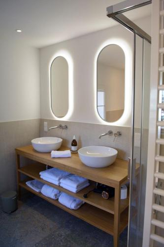 two sinks in a bathroom with two mirrors at Villa Nicoletta - Luxus am See - Your Austrian Home in Altaussee