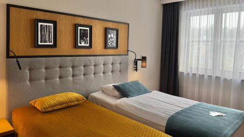 a bedroom with two beds and a window at Hotel Prezydent in Spała