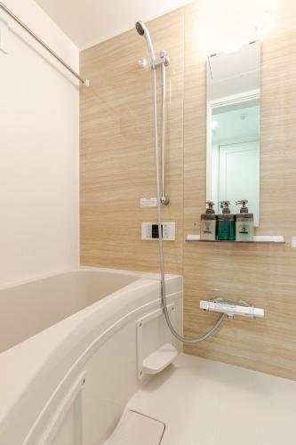 a bathroom with a white tub and a mirror at ksf上池袋3丁目101 in Tokyo