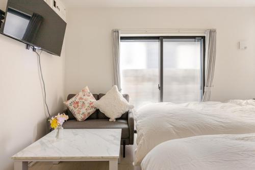 東京にあるksf上池袋3丁目101のベッドとソファとテーブルのある寝室