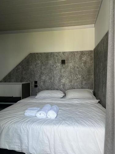 a white bed with two towels on top of it at Coolplay house in Bangkok