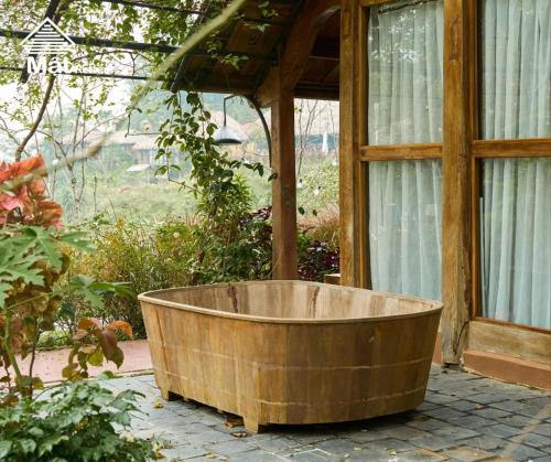a wooden tub sitting outside of a house at Mật Retreat in Ba Vì