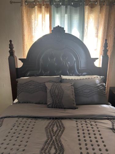 a large bed with a blue headboard and pillows at Lux Sea View Camelot Village Discovery Bay in Discovery Bay