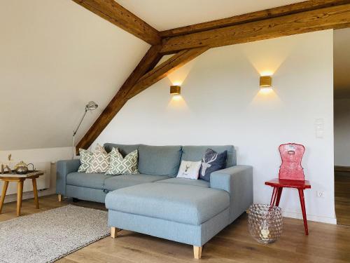 a living room with a blue couch and a table at Ferienwohnung Haus Alpenblick in Lenzkirch
