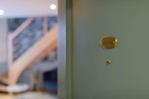 a door with a gold door knob on it at Le Logis d'Origine. in Marly-le-Roi
