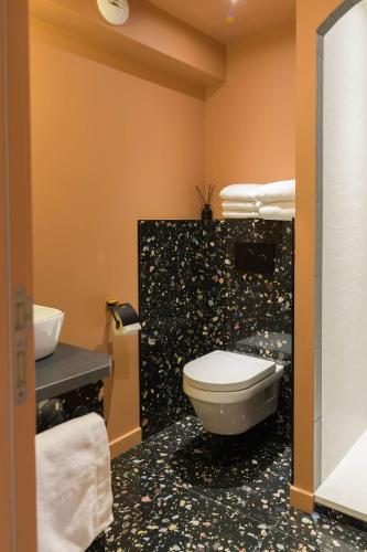 a bathroom with a toilet and a sink at Le Logis d'Origine. in Marly-le-Roi