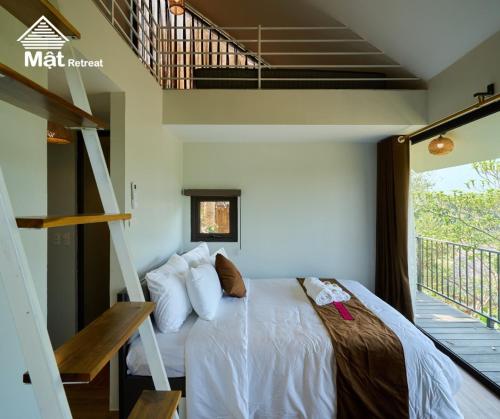 a bedroom with a bed in a room with a balcony at Mật Retreat in Ba Vì