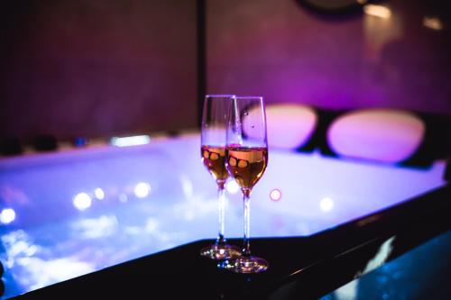 - deux verres de vin assis sur une table dans l'établissement FRENCH KlSS - Love Room by PRIM0 C0NCIERGERIE, à Clermont-Ferrand