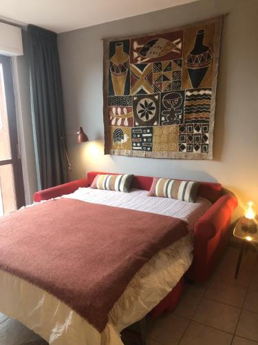 ein Schlafzimmer mit einem Bett mit einer roten Decke in der Unterkunft Camelia 07 in Acquaseria