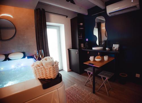 a bathroom with a tub and a table and a mirror at FRENCH KlSS - Love Room by PRIM0 C0NCIERGERIE in Clermont-Ferrand