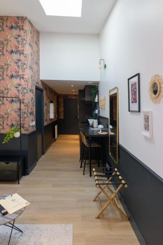 a hallway with a table and chairs in a room at Le Logis d'Origine. in Marly-le-Roi