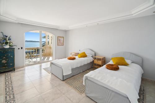 Cet appartement comprend une chambre avec deux lits et un balcon donnant sur l'océan. dans l'établissement Panorama d'Exception Piscine Chauffée proche de la mer dans un Domaine privée, à Grimaud