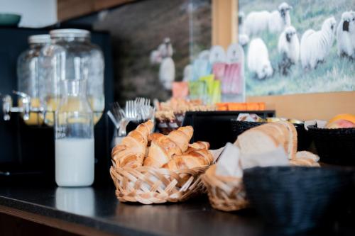a table topped with baskets of bread and milk at Chalet Sepp in Belalp