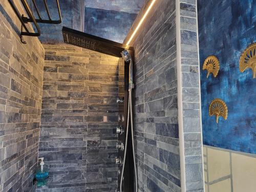 a shower in a bathroom with a brick wall at Dimora in San Quirico d'Orcia in San Quirico dʼOrcia