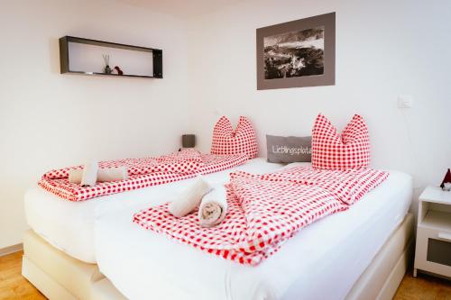 a bedroom with two beds with red and white pillows at Chalet Sepp in Belalp