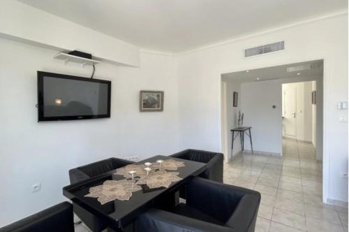 d'une salle à manger avec une table et une télévision murale. dans l'établissement Stylish 3P, 2 pas la Croisette, à Cannes