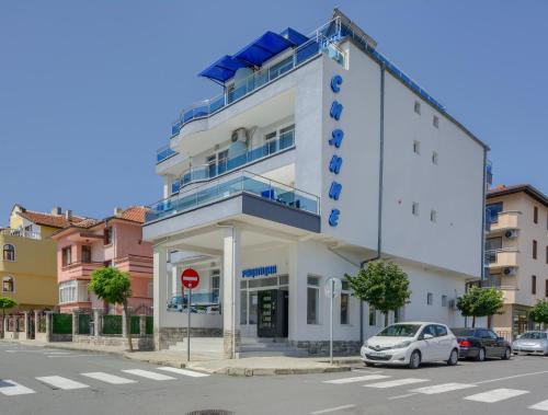 a white building with a balcony on a street at Siyanie Kiten in Kiten