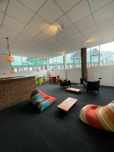 a large room with chairs and tables on the floor at Journey Junction Hostel in Nuwara Eliya