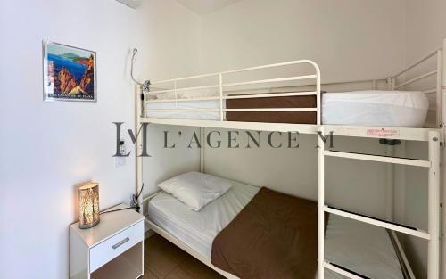 Cette petite chambre comprend 2 lits superposés et un bureau. dans l'établissement Studio Bis Rivages 100m de la plage, lumineux, à Calvi