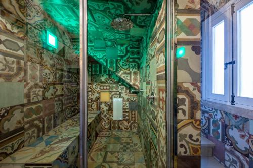 a shower in a room with a wall covered in graffiti at Palazzo Arco Cadura Hotel & Spa in Galatina