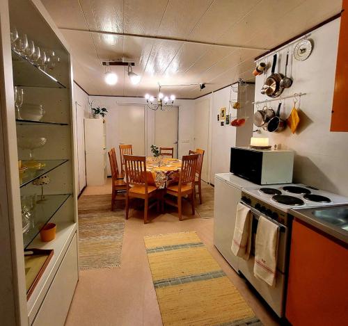 a kitchen and dining room with a table and a stove at Ainola Arctic Hillside in Rovaniemi
