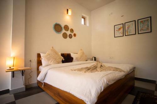 a bedroom with a large bed with white sheets at Hidden Lake By Vista Stays in Bhīm Tāl
