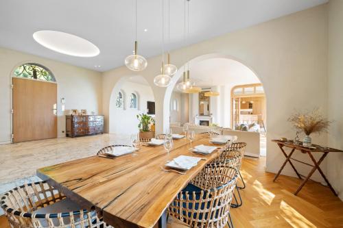 une salle à manger avec une grande table et des chaises en bois dans l'établissement Villa Grand Largue - vue mer 180°, à Cannes
