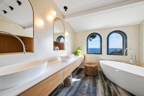 deux lavabos dans une salle de bain avec deux miroirs dans l'établissement Villa Grand Largue - vue mer 180°, à Cannes