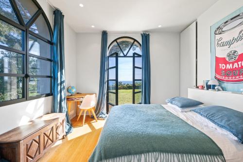 une chambre avec un lit, un bureau et une fenêtre dans l'établissement Villa Grand Largue - vue mer 180°, à Cannes