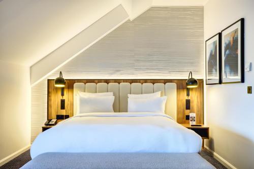 a bedroom with a large white bed and a staircase at Radisson Blu Hotel, Durham in Durham