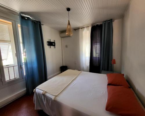 - une chambre avec un grand lit blanc et des rideaux bleus dans l'établissement Vacation location, à Tourrette-Levens