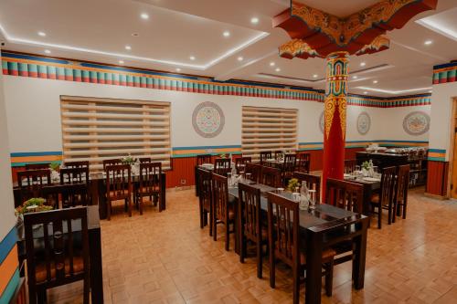a restaurant with tables and chairs in a room at Hotel Ever in Leh