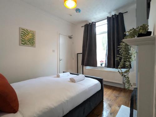 a bedroom with a bed with white sheets and a window at Modern Double Room W Private Bath & Free Parking in York