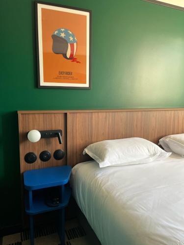 a bedroom with a bed and a picture on the wall at Hotel Le Lumière in Lyon