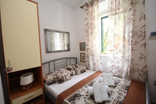Schlafzimmer mit einem Bett mit weißer Bettwäsche und einem Fenster in der Unterkunft Apartment Adriatica City in Makarska