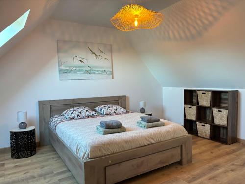 une chambre avec un lit avec deux oreillers dessus dans l'établissement Saint Ho Mer Maison lumineuse vue mer 8 pers 4 chambres 2 sdb 2 WC étage rénové en 2025 belle terrasse grand jardin clos parking 8 mn à pied petite plage grand jardin près de Port en Bessin, Bayeux et plage Omaha beach, à Sainte-Honorine-des-Pertes