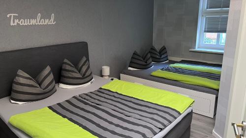 two beds in a bedroom with green and gray at Altstadt Fewo Wernigerode in Wernigerode