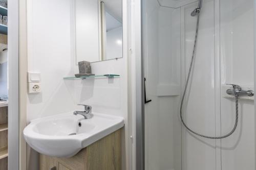 biała łazienka z umywalką i prysznicem w obiekcie Mobilhome 6-8 personnes Cap Ferret w mieście Lège-Cap-Ferret
