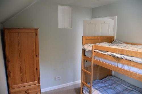 Un dormitorio con dos literas y un armario. en Munro Cottage, en Rockcliffe