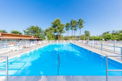a large swimming pool with blue water at Mobil-home Andernos Les Bains 4pers in Andernos-les-Bains