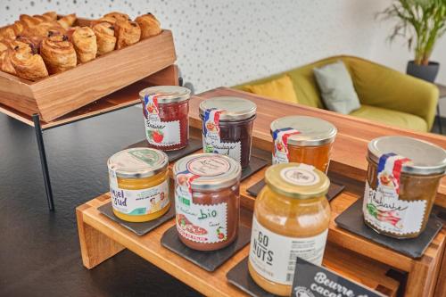 a table with jars of honey and some bread at Appart'hôtel Odalys City - Monaco Les Hauts de la Principauté in Beausoleil