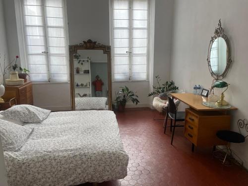 a bedroom with a bed and a desk and a mirror at Liberté in Marseille