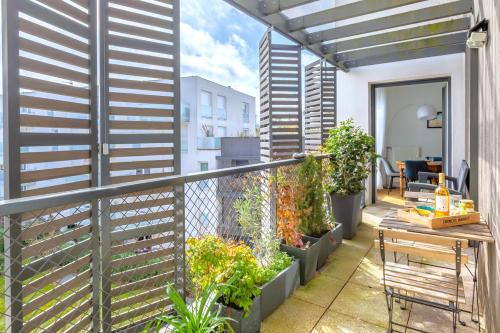 a balcony with plants and a table and a fence at Beautiful 2 bedroom in Palaiseau Ideal for professionals in Palaiseau