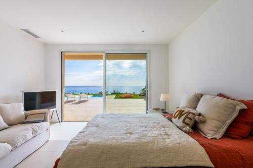 une chambre avec un grand lit et un canapé dans l'établissement Ibaia, à Saint-Aygulf