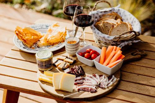une table avec une assiette de nourriture et un verre de vin dans l'établissement les bulles perchées de lartigue, à Margouët-Meymès