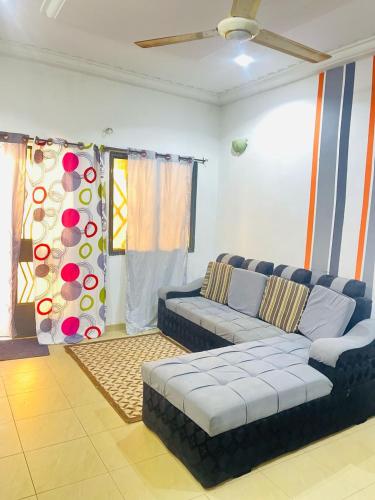 ワガドゥグーにあるRésidence Maévaのソファと窓のあるリビングルーム