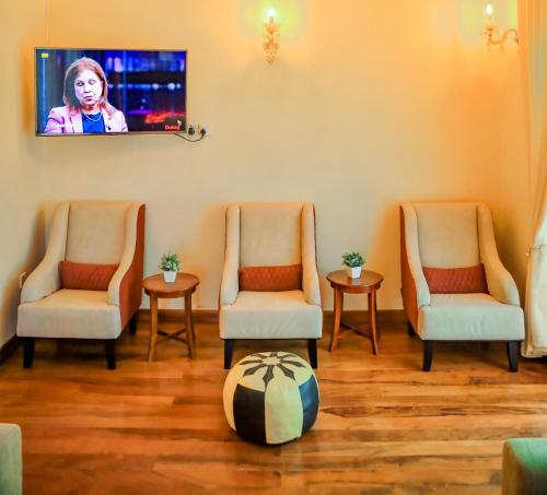 una sala d'attesa con due sedie e una tv a muro di Alben Castle Glenfall a Nuwara Eliya