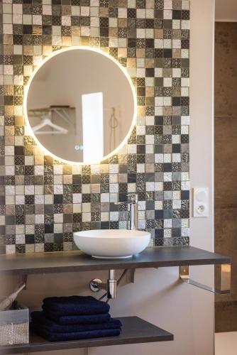 a bathroom with a sink and a mirror at LA DOLOREANNE in Saint-Didier-sur-Chalaronne