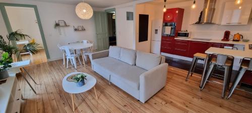 un salon avec un canapé et une table dans l'établissement Appartement chaleureux en centre-ville - Parking, à Pau