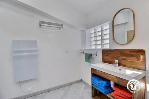 une salle de bain avec un lavabo et un miroir dans l'établissement Ty drenek, à Arradon